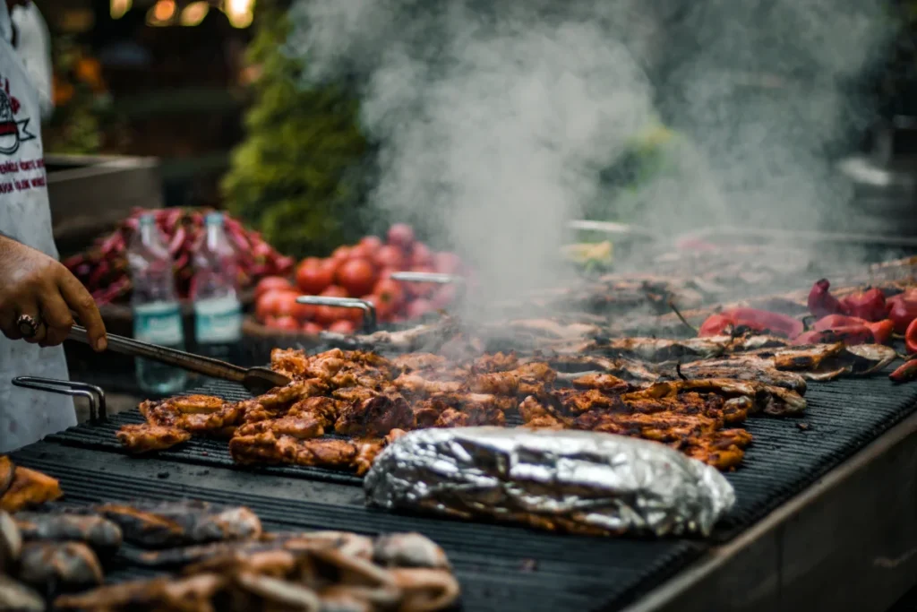 A Traeger grill with various dishes including brisket, pizza, and vegetables