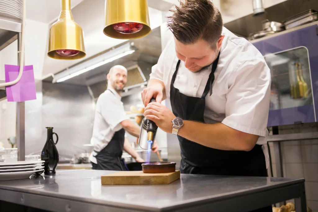 Blowtorch caramelizing sugar on a ramekin of Crab Brulee