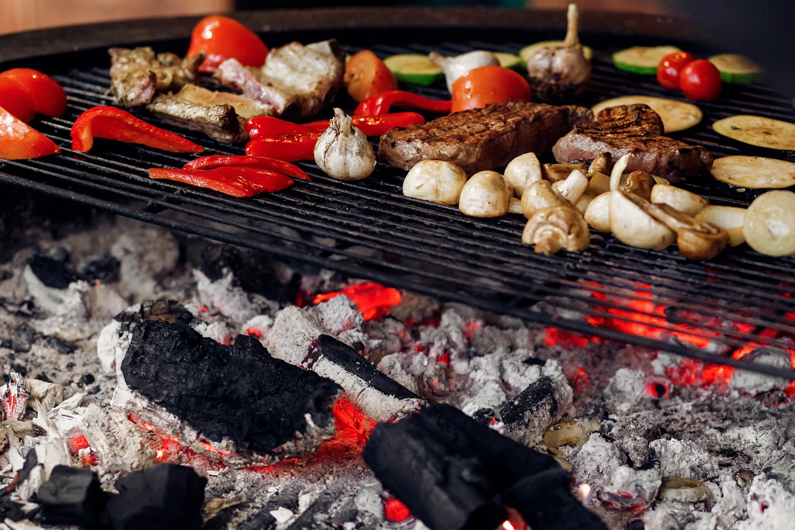 Traeger grill with a variety of food cooking, including meats and vegetables